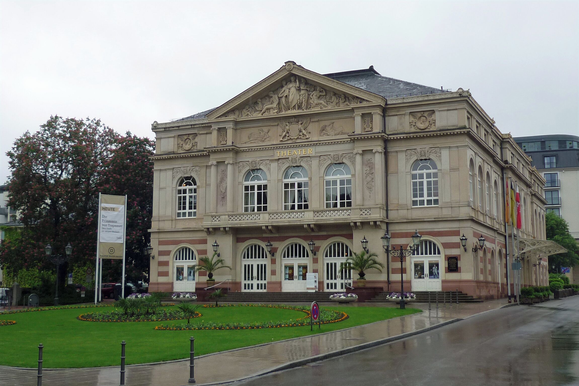 A historic theater building with classical architecture, large arched windows, and a central entrance.