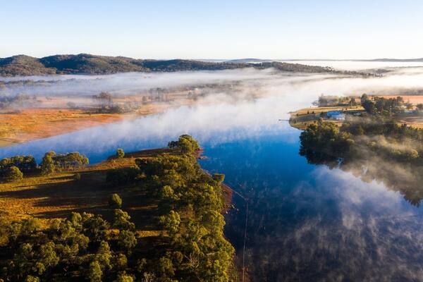 Storm King Dam showing a river or creek, a sunset and mist or fog