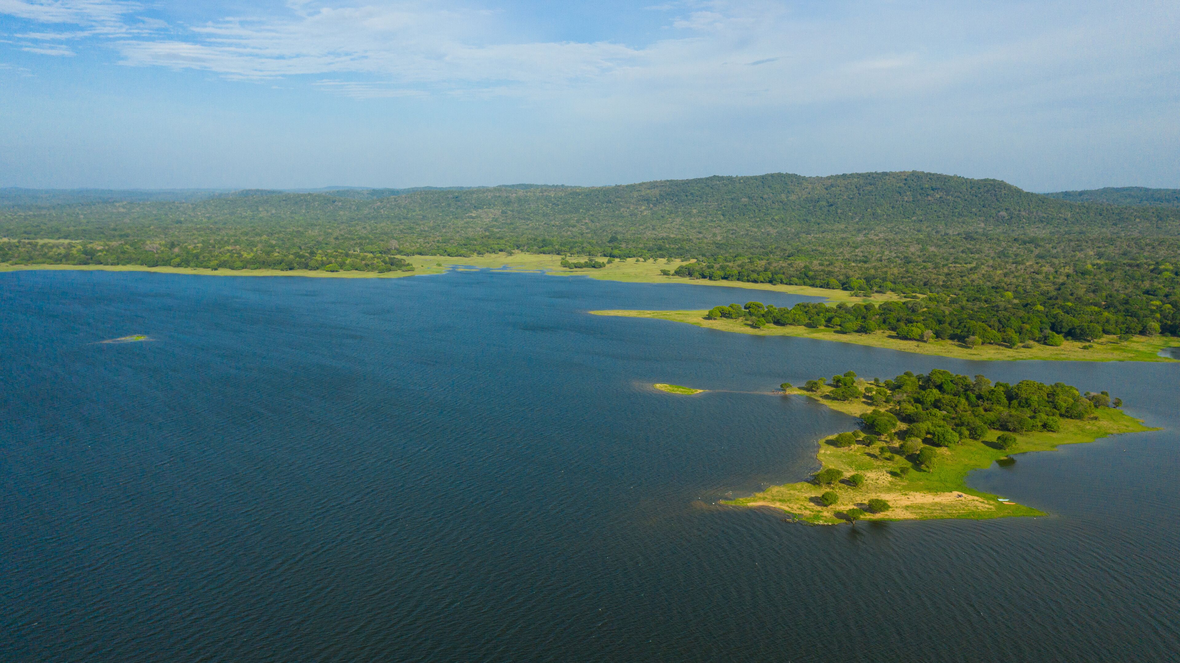 Lake in the background of mountains with tropical forest and jungle. Kantale tank, Sri Lanka.