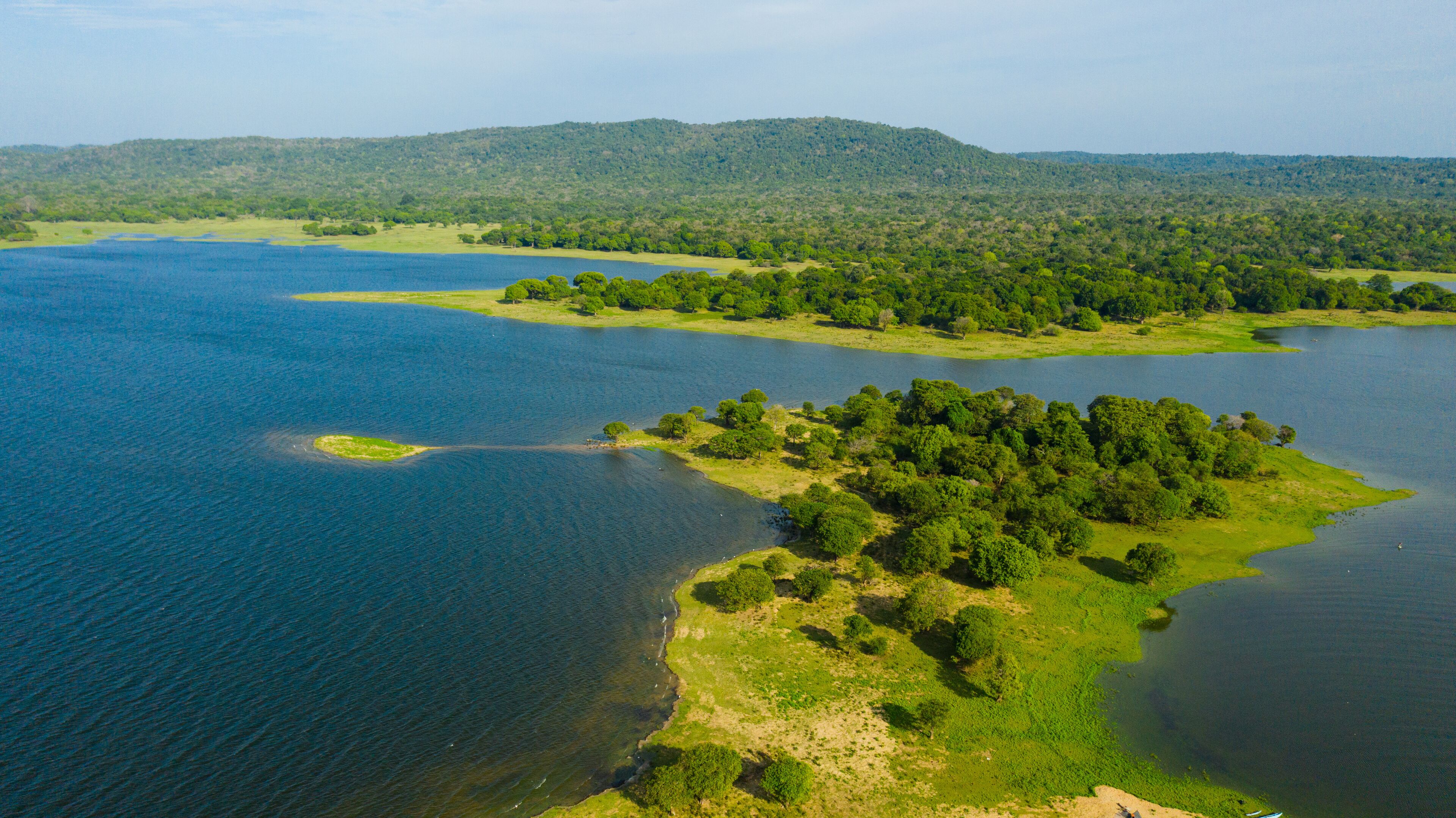 Aerial view of Lake in the background of mountains with tropical forest and jungle. Kantale tank, Sri Lanka.