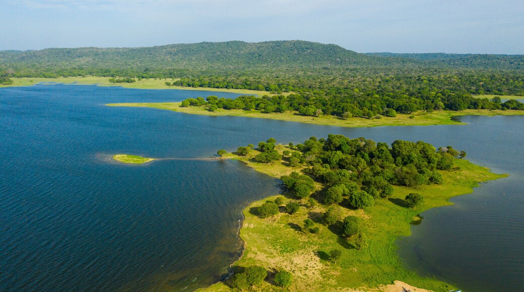 Aerial view of Lake in the background of mountains with tropical forest and jungle. Kantale tank, Sri Lanka.