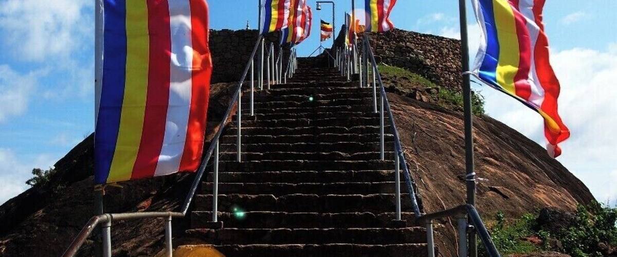 A staircase leading up a hill with multiple flags on either side.