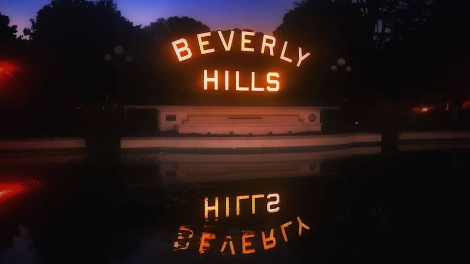 Beverly Hills is a city in California's Los Angeles County. Home to many Hollywood stars, it features the upscale shopping street of Rodeo Drive. The expansive Beverly Gardens Park has fountains and rose gardens, plus an illuminated Beverly Hills sign. The 1920s Greystone Mansion is the backdrop for many films. Known as a celebrity haunt, The Beverly Hills Hotel is set in tropical gardens and has a poolside cafe.