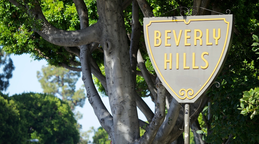 Sign marking Beverly Hills, California, surrounded by lush greenery and vibrant trees on a sunny day