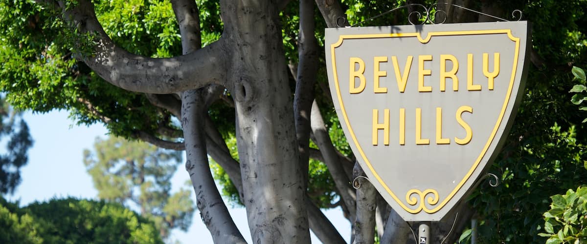 A sign reading "BEVERLY HILLS" mounted on a tree.