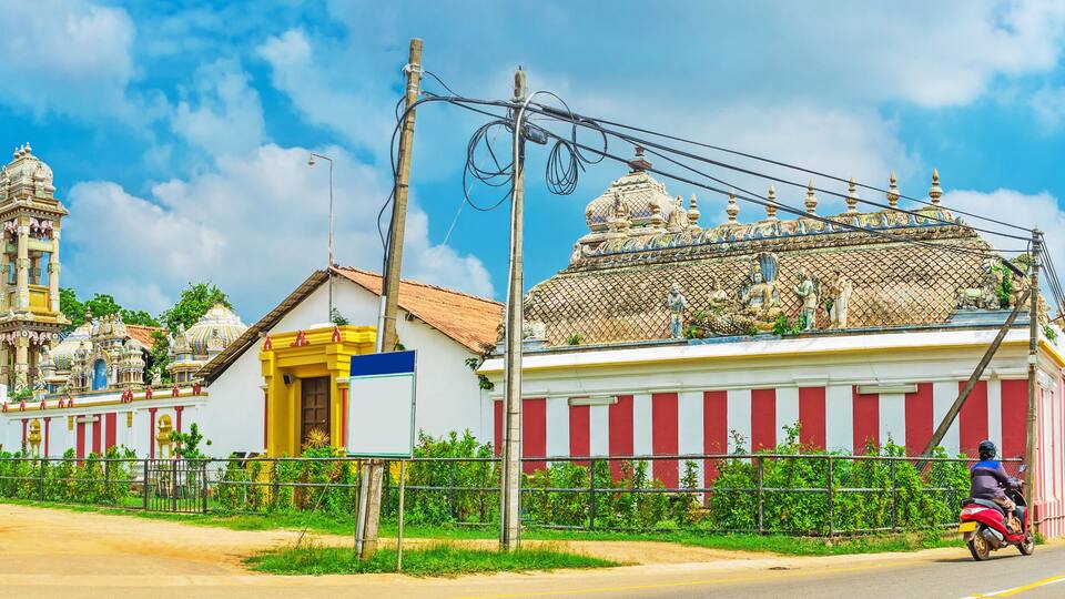 A temple with intricate architecture and a person on a motorcycle.