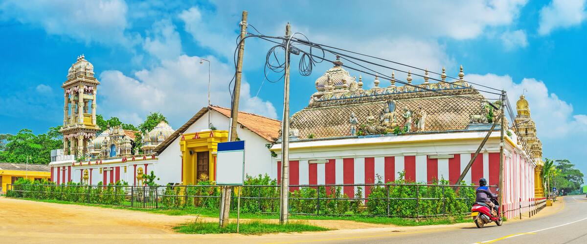 A temple with intricate architecture and a person on a motorcycle.