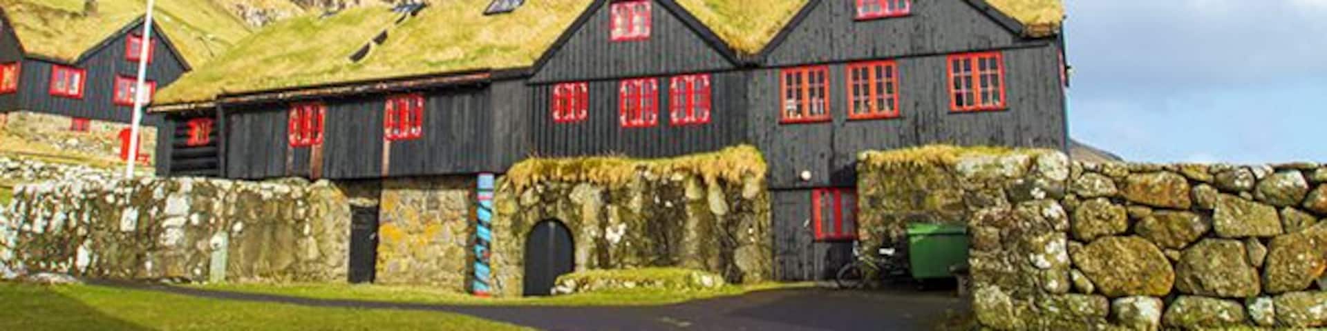 The hike from Torshavn to the old bishopric and royal residence where the Norwegian King Sverre grew up, takes a few hours. In the Middle Ages Kyrkjebo was the cultural and religious center in the Faroe Islands. The old log house is told to be Europe’s oldest timber building, around 900 years old. John Patursson is the host and farmer at Kyrkjebo, he’s 17. generation onsite. Read more on: http://www.travelwithallsenses.com/faroe-islands-treat-for-all-senses/