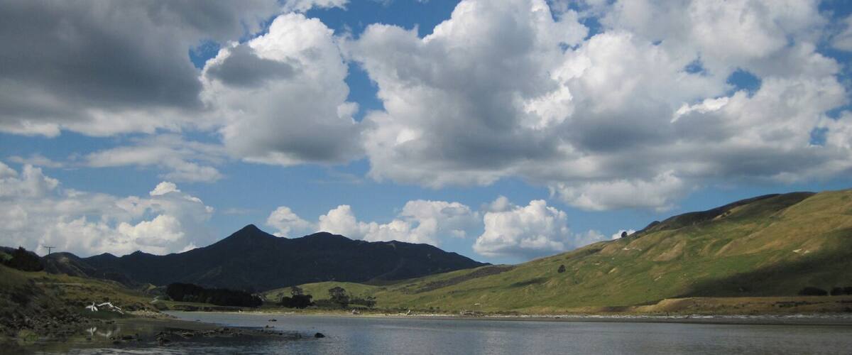 A lake with mountains in the background and a partly cloudy sky.