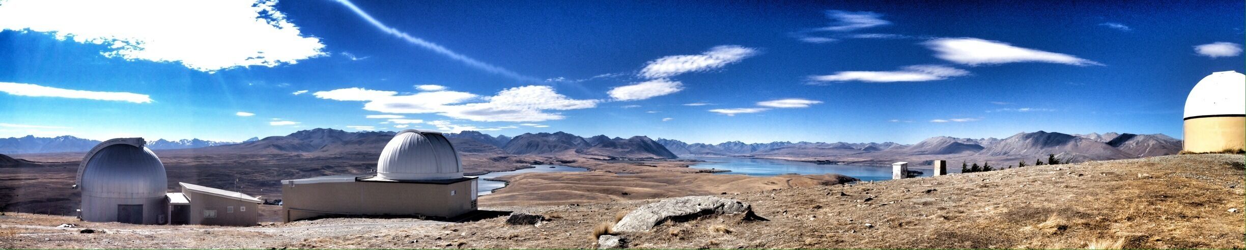 A mountainous landscape with observatories and a lake.