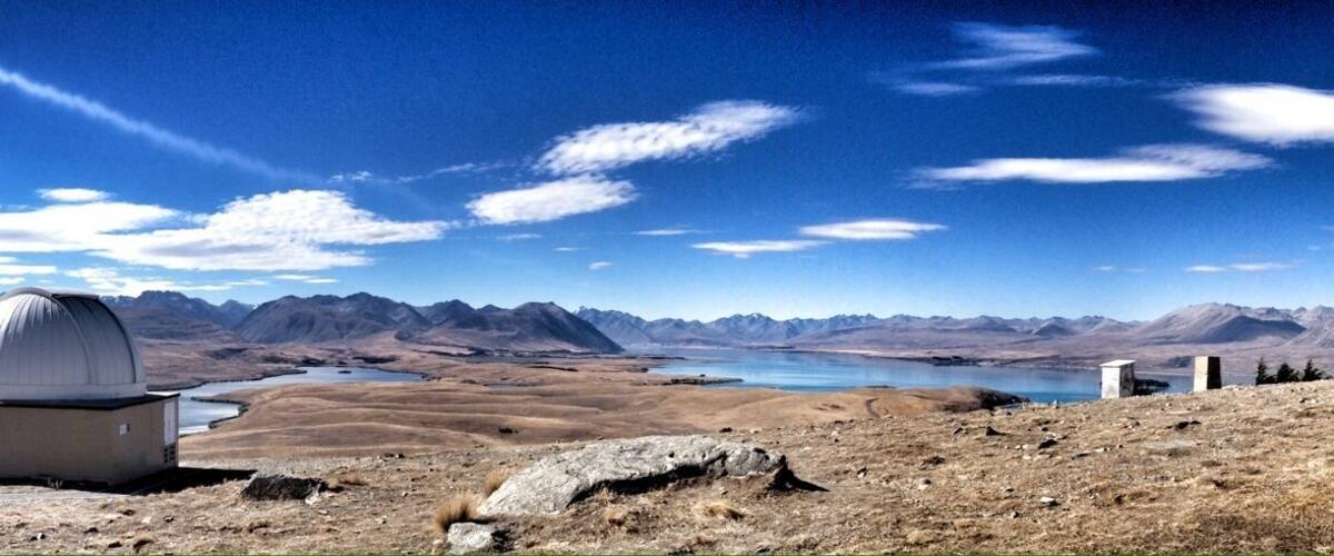 A mountainous landscape with observatories and a lake.