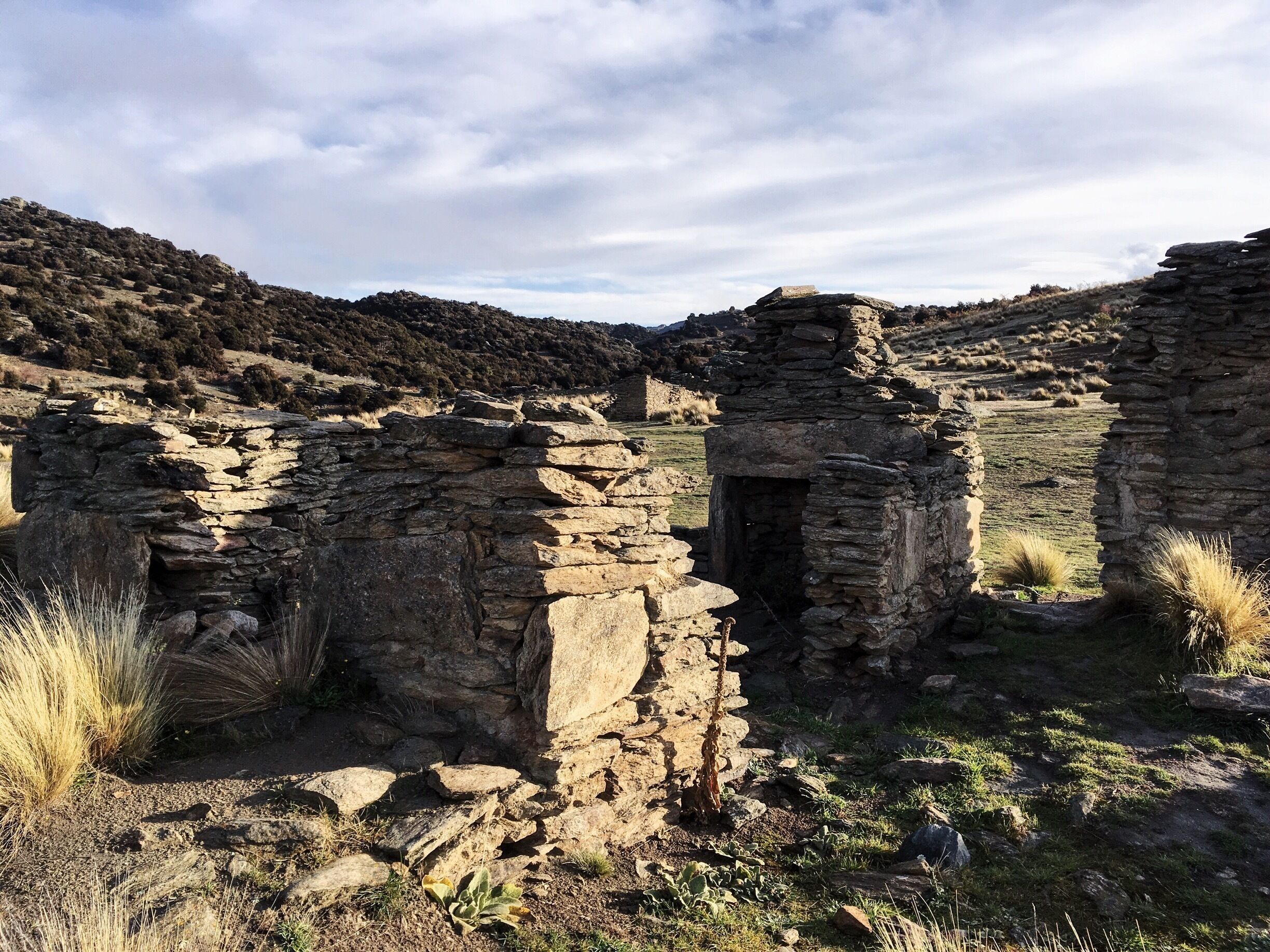 Ancient stone ruins in a hilly landscape.
