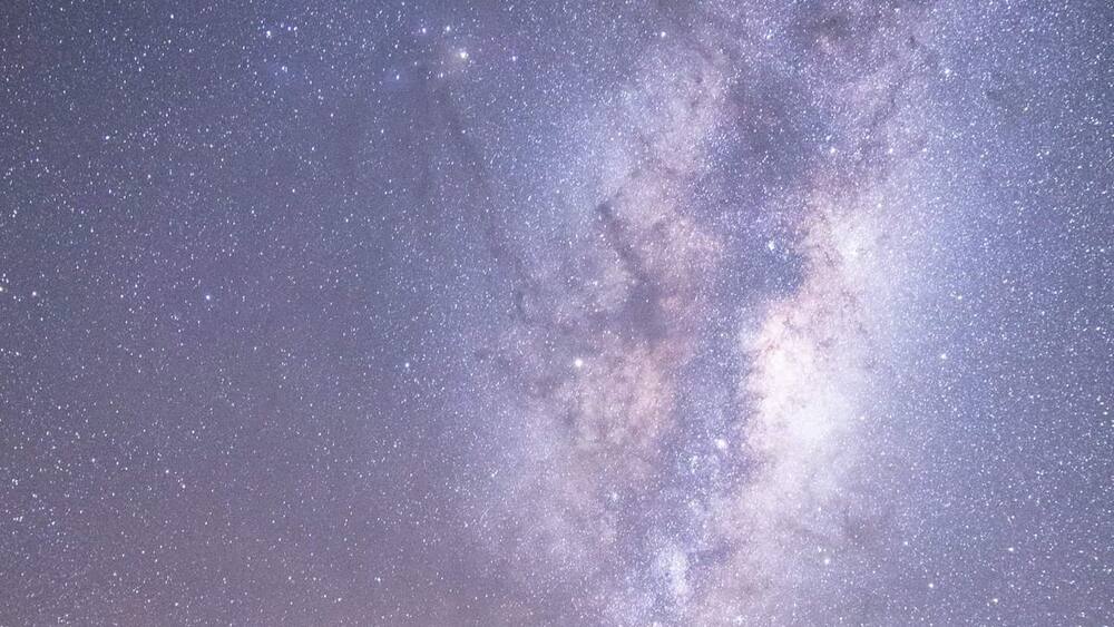 A starry night sky over a mountainous landscape.
