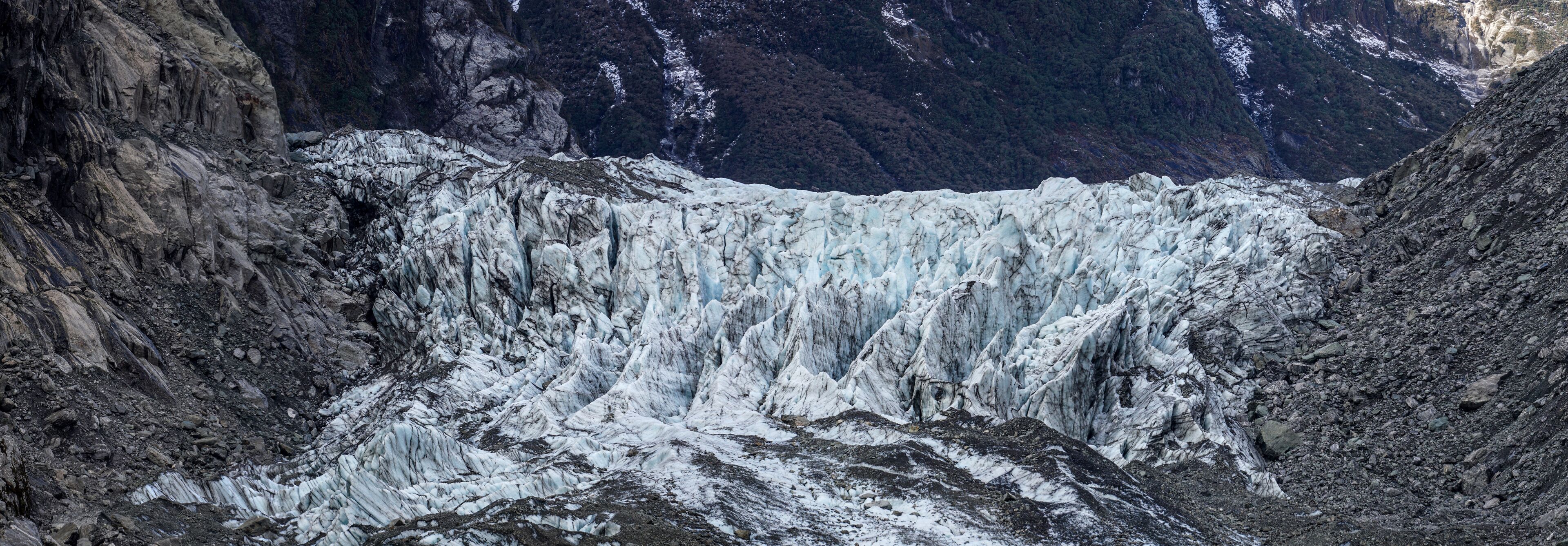 A glacier with steep, rugged cliffs and a deep crevasse.