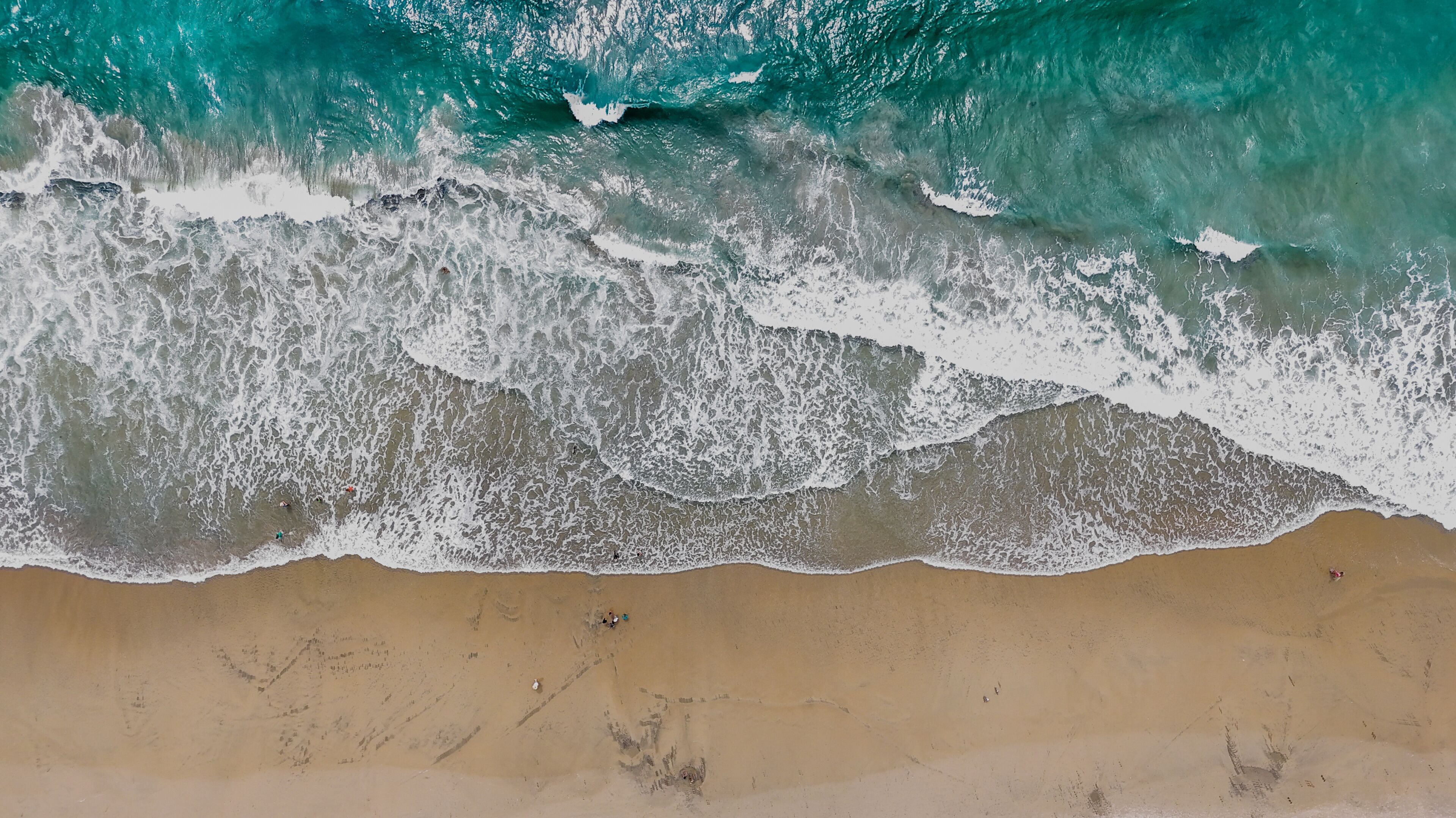 Aerial nature top down ocean waves on the beach southern Del Mar San Diego California CA