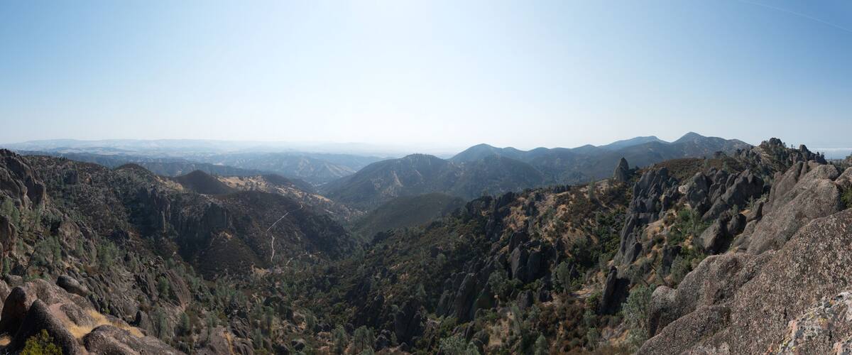 A rugged mountainous landscape with rocky outcrops and dense vegetation.