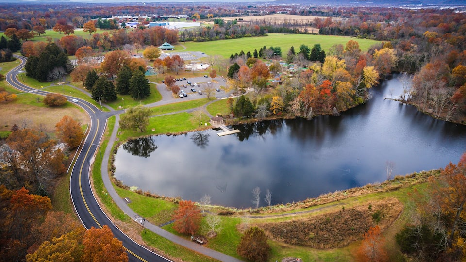 A winding road, a lake, and autumn-colored trees.
