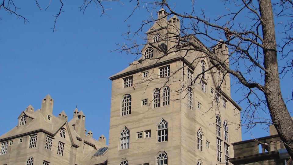 A large, historic building with multiple towers and arched windows.