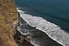 Aerial view of white foamy ocean waves, black volcanic sandy beaches and rocky cliffs. Sunny day, blue sky. Pacific coast of El Salvador.