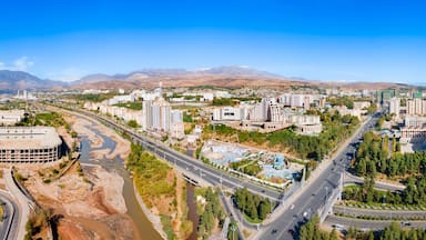 A cityscape with a river, roads, and mountains in the background.