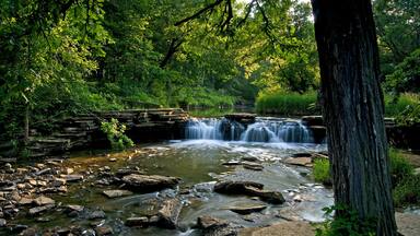 A stream swollen with spring rains spills over a picturesque waterfall.
