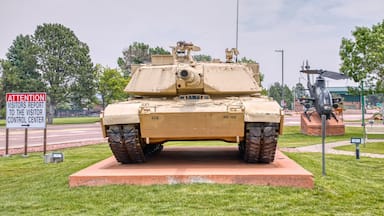 Un char d’assaut est exposé, accompagné d’un panneau indiquant aux visiteurs le chemin vers le centre d’accueil.