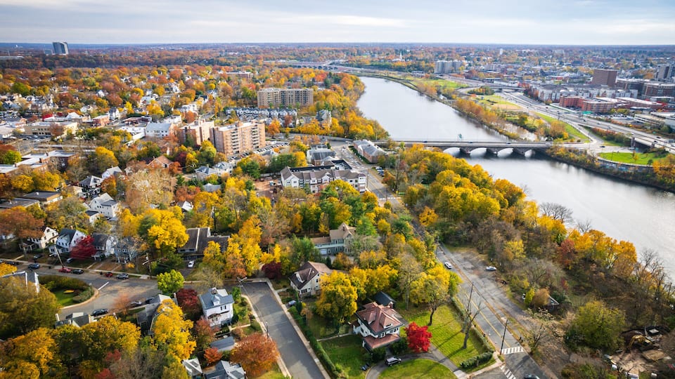 A river winding through a city with autumn foliage, bridges, and residential areas.