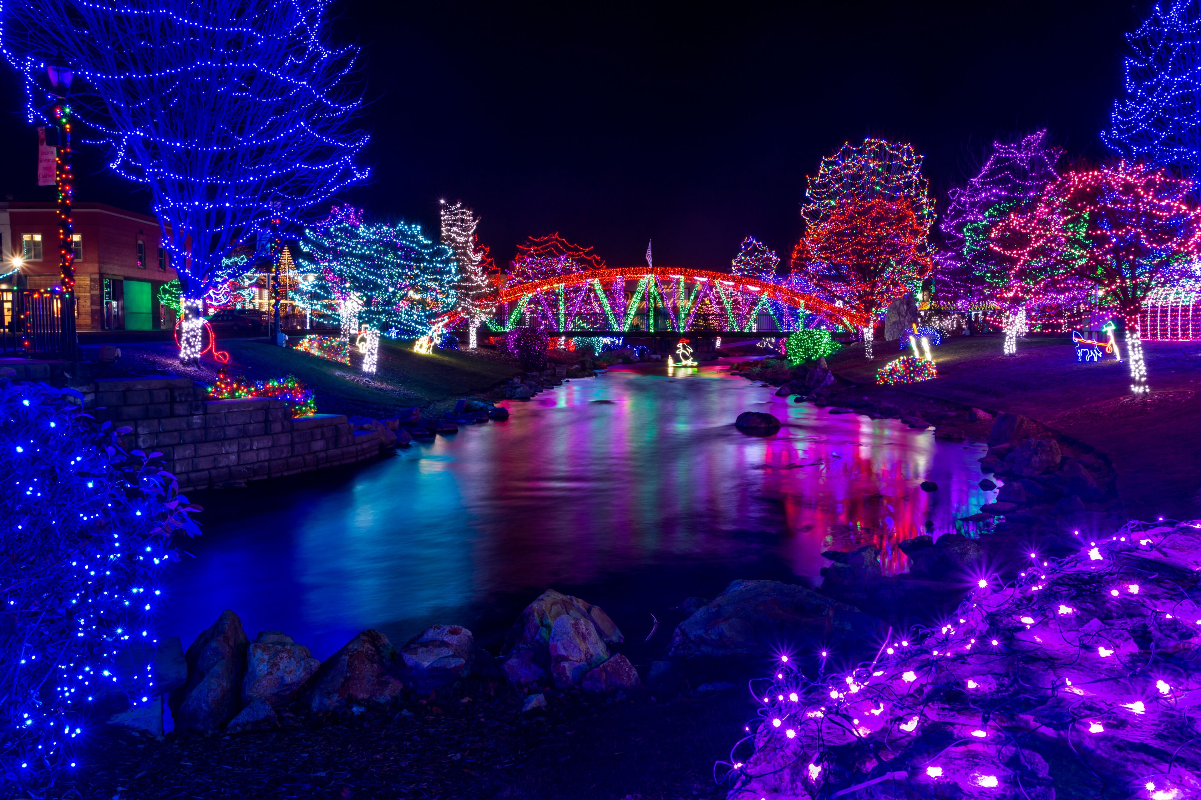 Beautiful park decoration and lights for Christmas. Lights are reflected in the flowing water. Location is Caldwell, Idaho, Indian Creek Park
