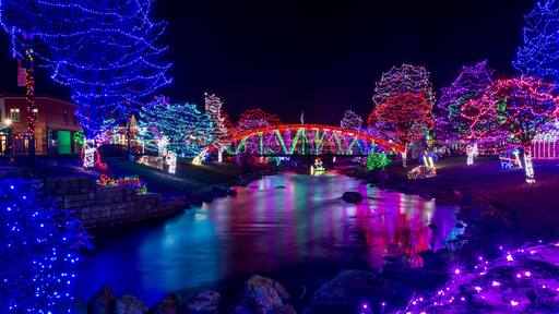 Beautiful park decoration and lights for Christmas. Lights are reflected in the flowing water. Location is Caldwell, Idaho, Indian Creek Park