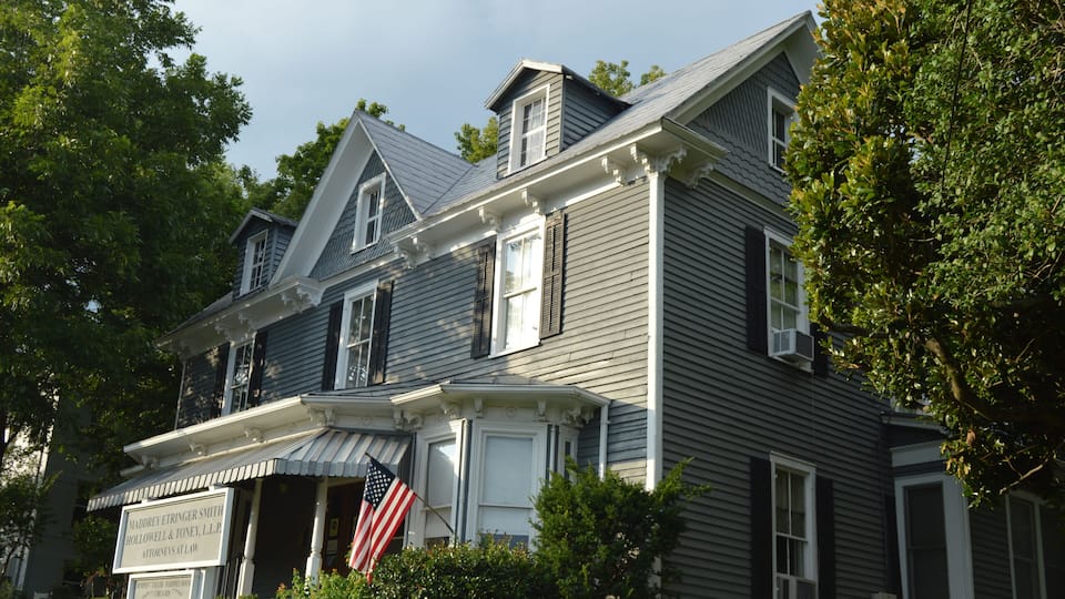 A large, gray house with a white porch and a sign for Madre Eringer Smith Hollowell & Toney, L.L.P.