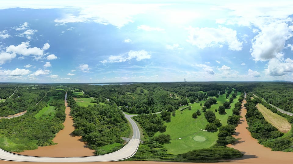 A river meandering through a green landscape with a winding road.