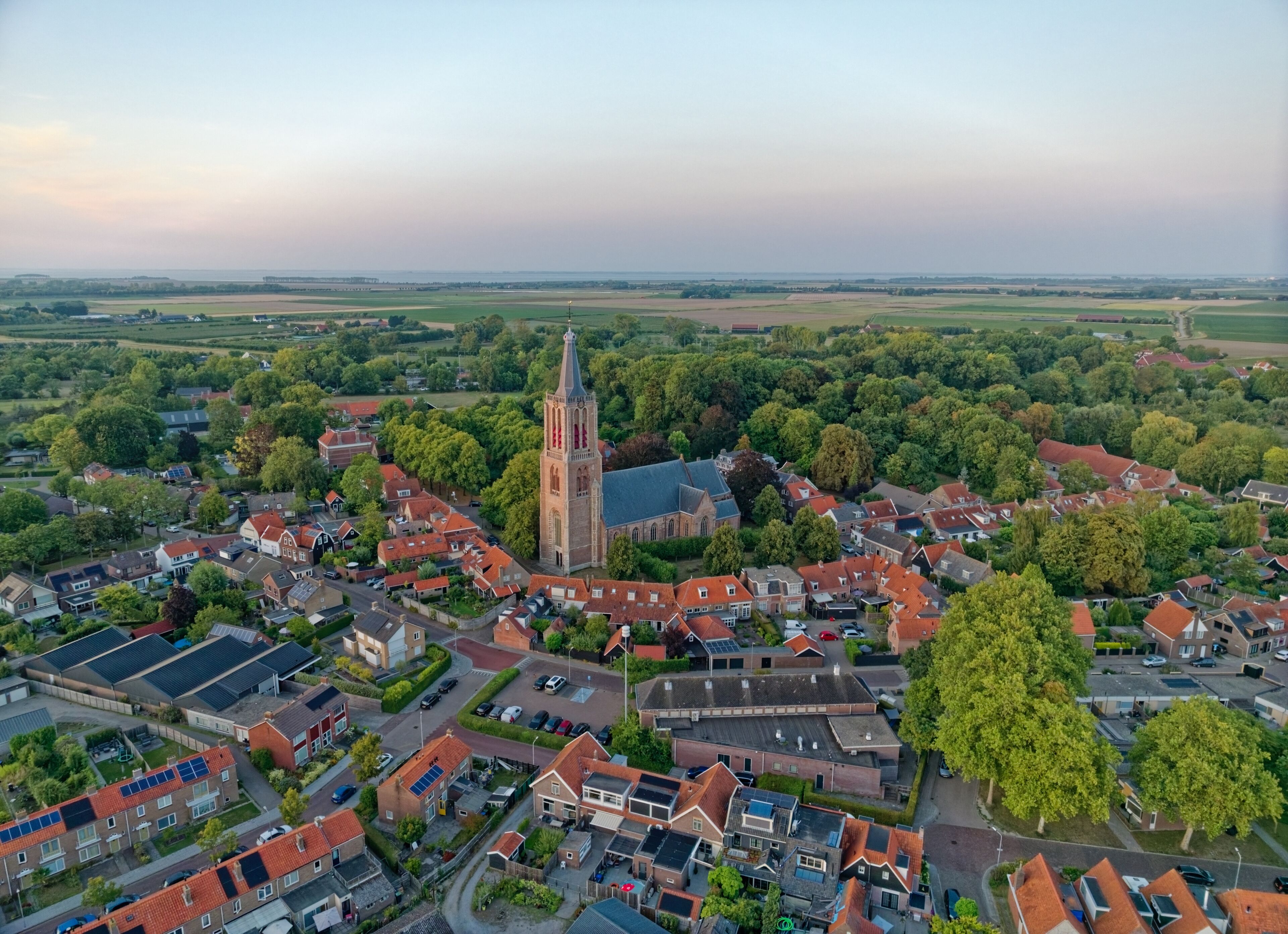 Typical Dutch church Geerteskerk in small town Kloetinge aerial view