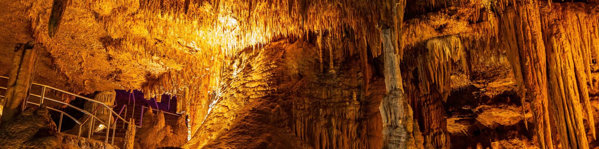 A cave with stalactites and a metal walkway.