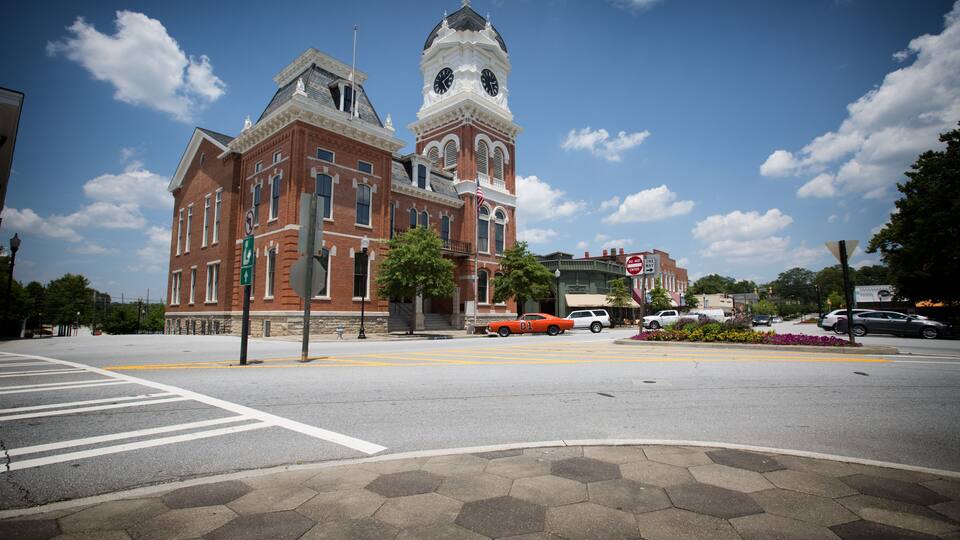 A historic building with a clock tower and a crosswalk in front.