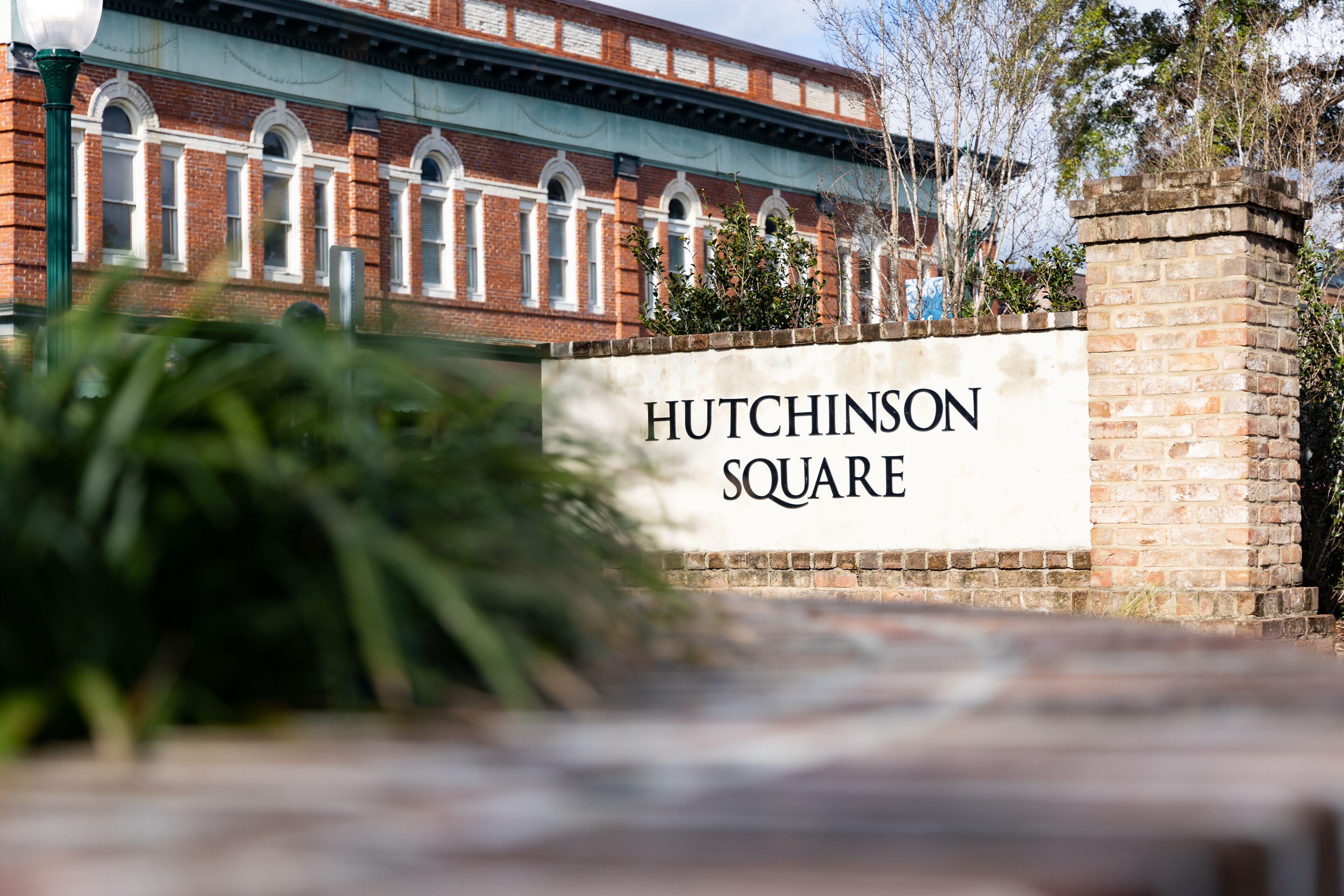 A brick building with arched windows and a sign reading "Hutchinson Square".