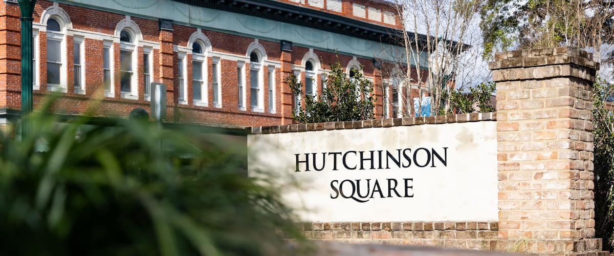 A brick building with arched windows and a sign reading "Hutchinson Square".