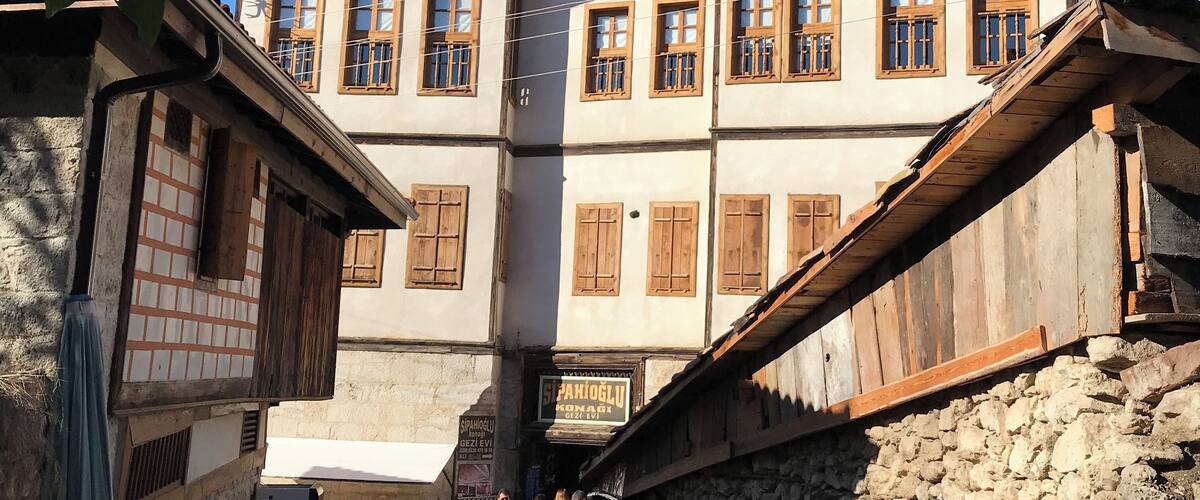 A traditional market street with stone buildings and wooden shutters.