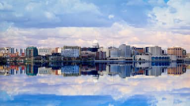 A city skyline with a prominent white dome building, reflecting in a calm body of water.