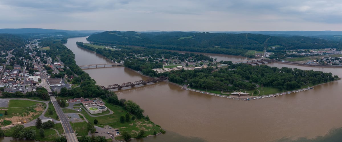 A river winding through a town surrounded by hills.