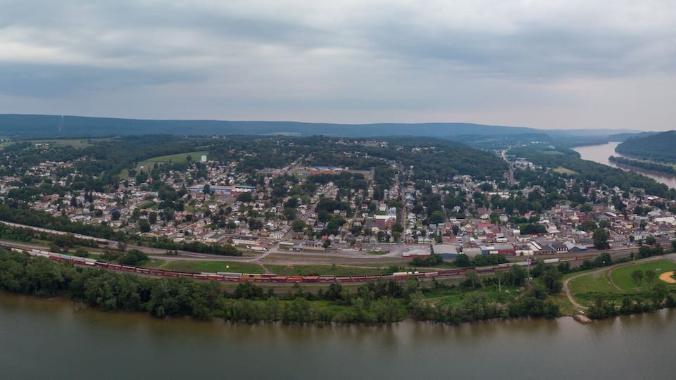 A river winding through a town surrounded by hills.