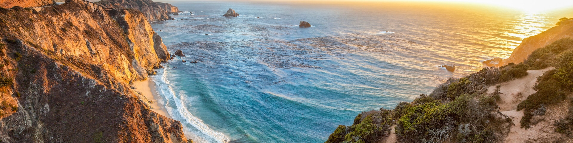 Un paisaje costero con acantilados, una playa y el océano.
