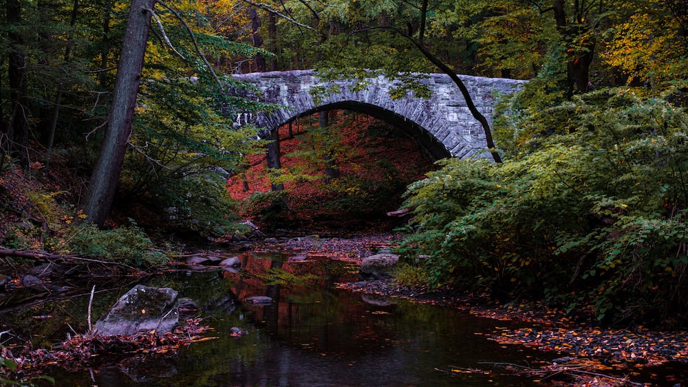 Stone bridge in Rockefeller State Park over the Pocantico River in autumn