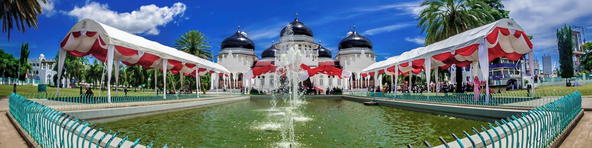 Baiturrahman Grand Mosque
The original Masjid Raya ("Grand Mosque") was built in 1612 during the reign of Iskandar Muda, Sultan of Aceh. Some say the original mosque was built even earlier in 1292 by Sultan Alaidin Mahmudsyah. The original royal mosque features a multi-tiered thatched roof, a typicalAcehnese architecture.
During the First Aceh Expedition, the mosque became a center of armed resistance to the Dutch and therefore it was destroyed razed to the ground on 6 Januari 1874 by the East Indies Governor General van Swieten. In March 1877, the Dutch offered to rebuild the mosque to the local rulers. Construction only began in 1879. The first stone was laid by Tengku Qadhi Malikul Adil who became the first Imam. Construction was completed on 27 December 1881 during the rulership of Muhammad Daud Syah, the last sultan of Aceh. Initially, many Acehnese refused to pray at Baiturrahman, because it was built by the Dutch with ambitions to conquer Aceh, however today it is the pride of Banda Aceh.
At first, the Baiturrahman Mosque featured one dome and one minaret. More domes and minarets were added in 1935, 1958 and 1982. Today the mosque has seven domes and eight minarets, including one that is claimed to be the highest minaret in Banda Aceh.
Baiturrahman Grand Mosque survived the 2004 earthquake and tsunami but suffered minor damages such as wall cracks. The earthquake had slightly tilted and cracked the 35 meter minaret by the main gate. During the disaster, The mosque served as a temporary shelter for displaced persons and only reopened for prayers after two weeks.