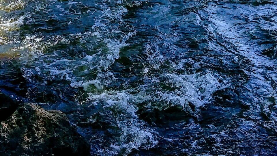 A turbulent river with visible rocks and flowing water.