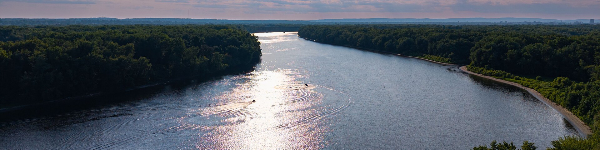 Un río serpentea a través de un paisaje boscoso bajo un cielo despejado.