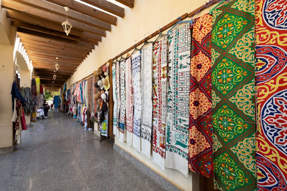 Un pasillo decorado con textiles de colores colgados en las paredes.