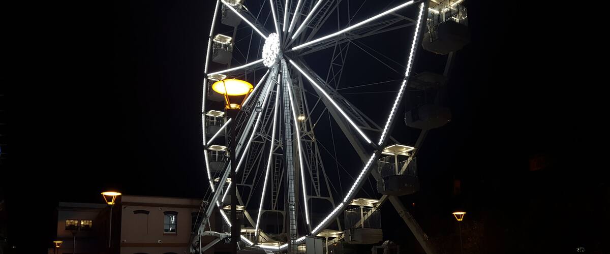 A large Ferris wheel with bright lights against a dark night sky.