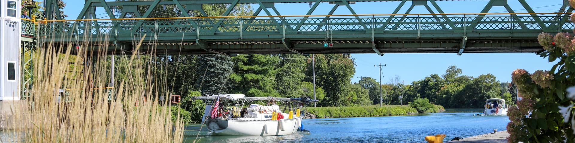 Sailboats passing under a raised lift bridge at Brockport, New York