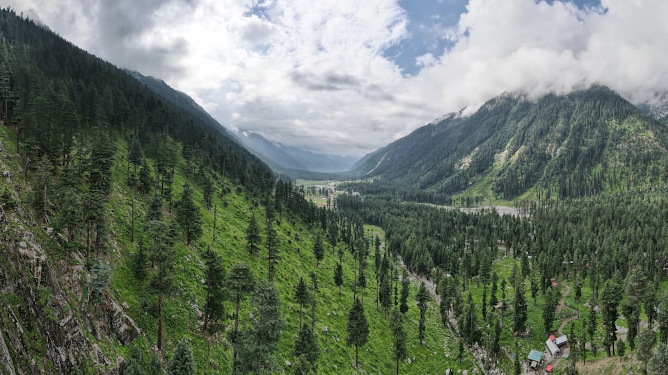 A mountainous landscape with dense forests and a valley.