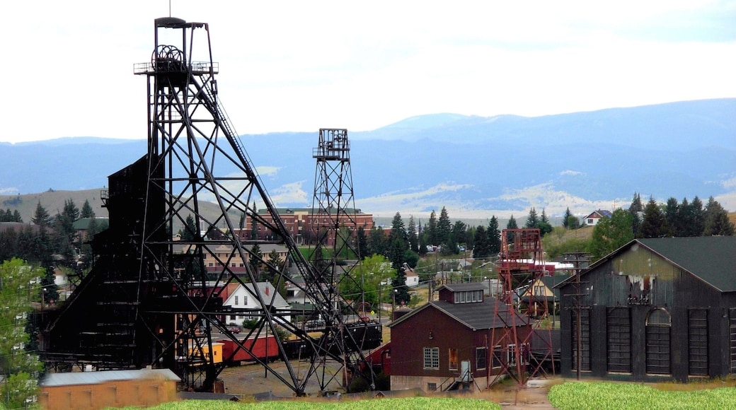 Butte que incluye elementos industriales, una pequeña ciudad o pueblo y montañas